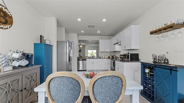 kitchen featuring appliances with stainless steel finishes, a textured ceiling, and white cabinets