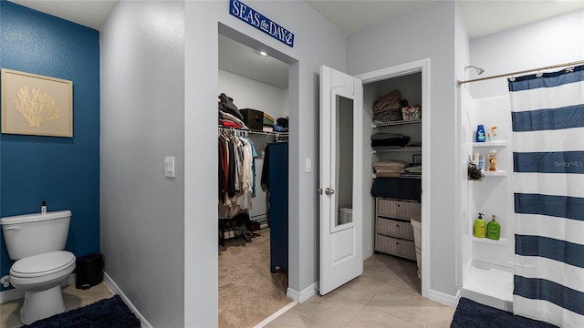 bathroom featuring tile patterned flooring, curtained shower, and toilet