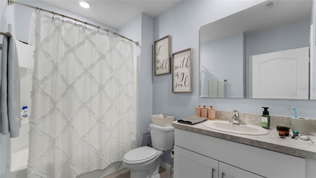 bathroom with walk in shower, vanity, and toilet