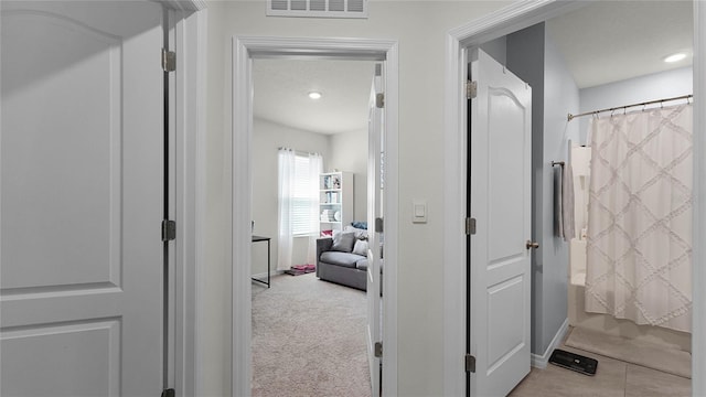 hallway with light colored carpet