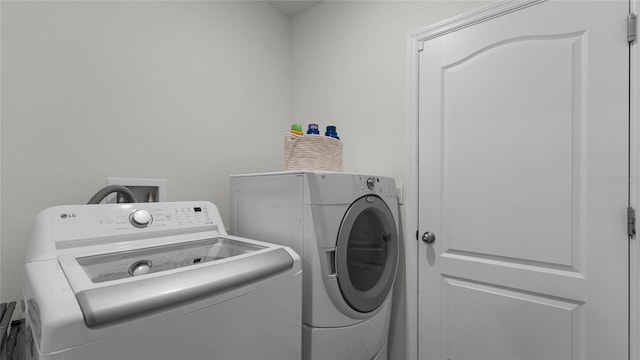 clothes washing area with washing machine and dryer