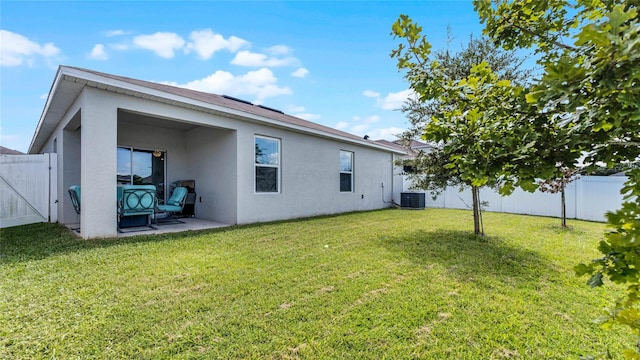 back of house with a yard, central air condition unit, and a patio area