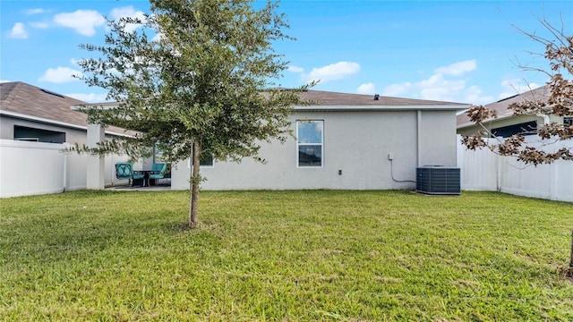 rear view of house featuring a patio area, central air condition unit, and a yard