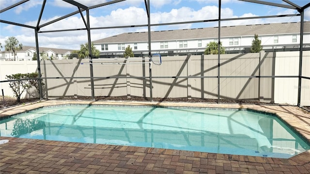 view of swimming pool featuring a lanai