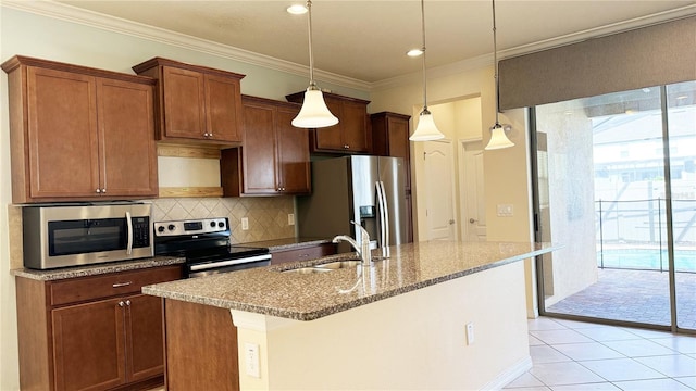 kitchen with appliances with stainless steel finishes, a center island with sink, decorative light fixtures, and light tile patterned floors