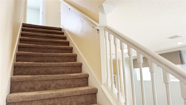 stairway with a textured ceiling