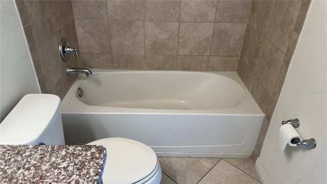 bathroom featuring toilet, tile patterned floors, and a bathing tub