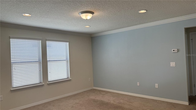 empty room with a textured ceiling, carpet floors, and ornamental molding