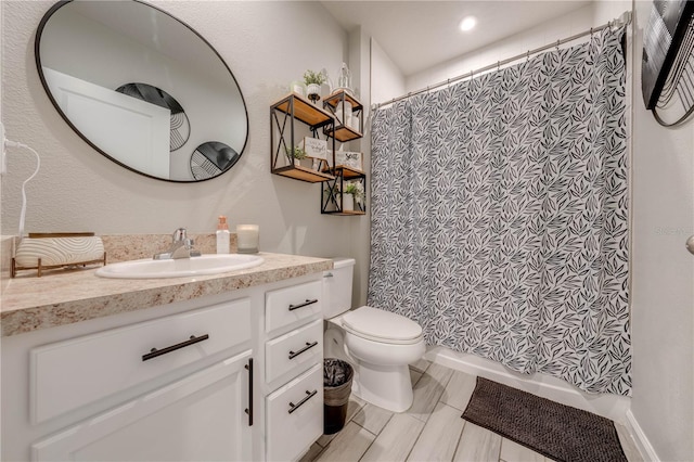 bathroom with vanity, toilet, and walk in shower