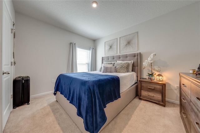 bedroom featuring a textured ceiling and light carpet