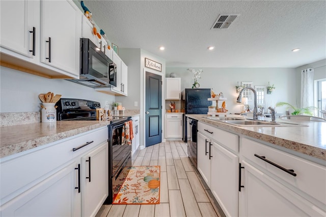 kitchen featuring white cabinets, light stone countertops, sink, black appliances, and a textured ceiling