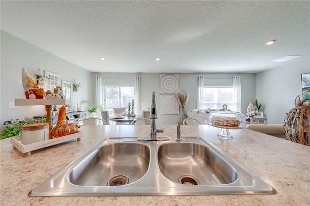 kitchen featuring a textured ceiling, a wealth of natural light, and sink