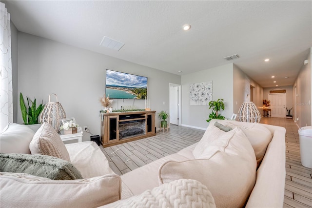 living room featuring light wood-type flooring and a fireplace