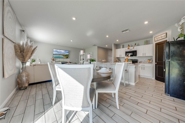 dining space featuring sink and light wood-type flooring