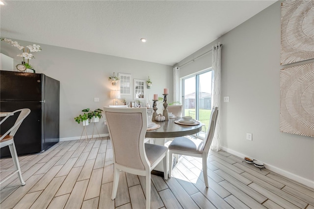 dining area featuring a textured ceiling and light hardwood / wood-style floors