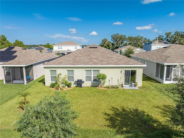 back of property with a sunroom and a yard