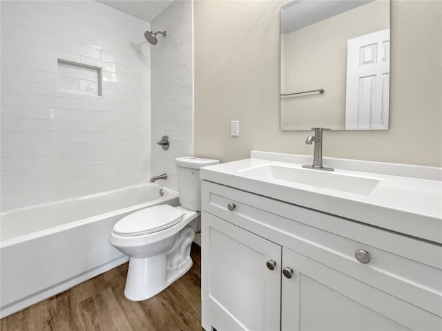 full bath with washtub / shower combination, vanity, wood finished floors, and toilet