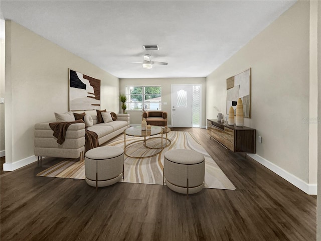 living room with baseboards, visible vents, ceiling fan, and wood finished floors