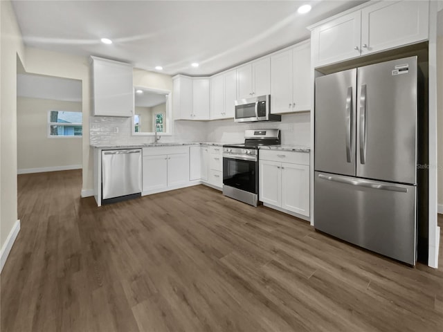 kitchen with stainless steel appliances, white cabinetry, sink, dark wood-type flooring, and tasteful backsplash