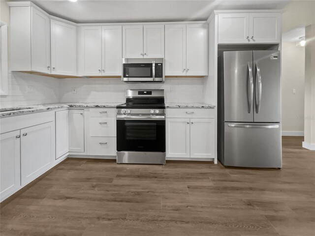 kitchen with appliances with stainless steel finishes, white cabinetry, and decorative backsplash