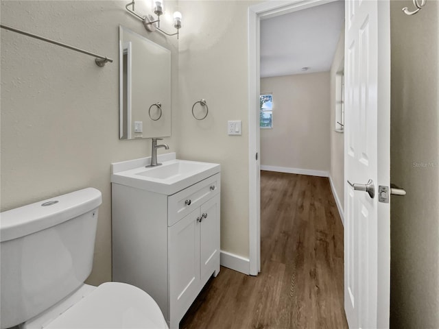 bathroom with vanity, toilet, and hardwood / wood-style flooring