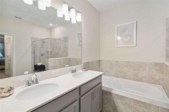 bathroom featuring shower with separate bathtub and vanity