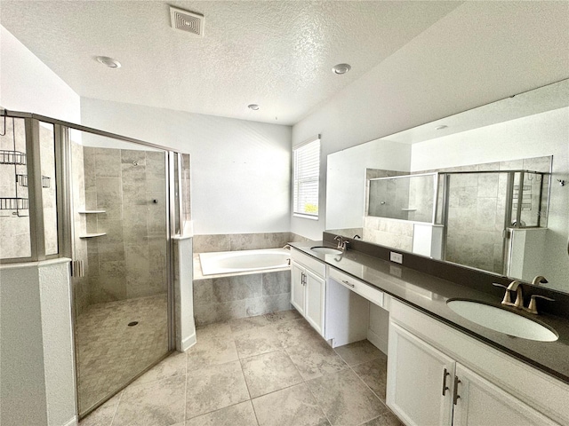 bathroom featuring tile patterned floors, independent shower and bath, a textured ceiling, and vanity