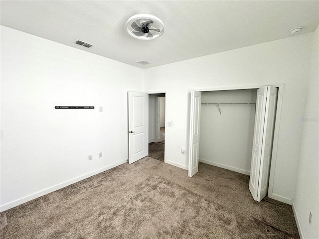 unfurnished bedroom with a closet, carpet flooring, and a textured ceiling