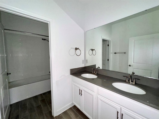 bathroom featuring vanity, lofted ceiling, hardwood / wood-style flooring, and shower / tub combination