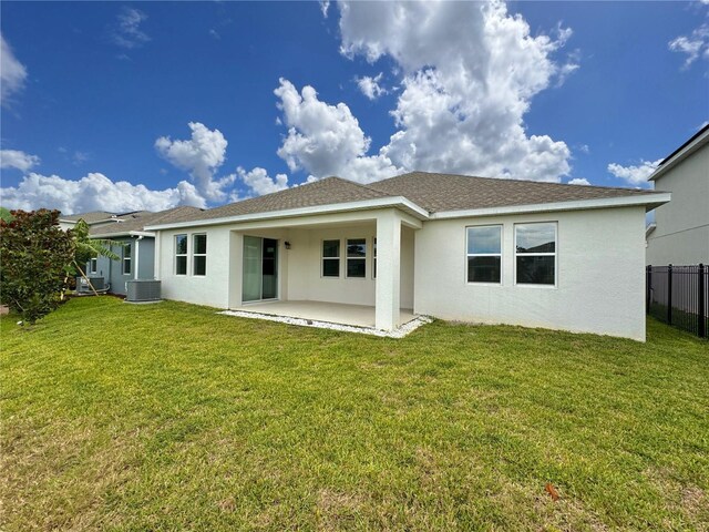 rear view of property with central AC, a lawn, and a patio area