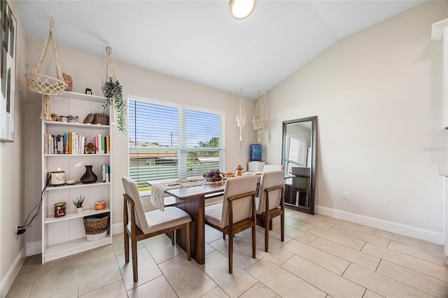 dining room with light tile patterned flooring and vaulted ceiling