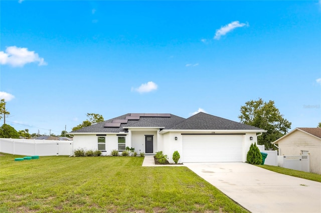 view of front of property with solar panels, a garage, and a front lawn