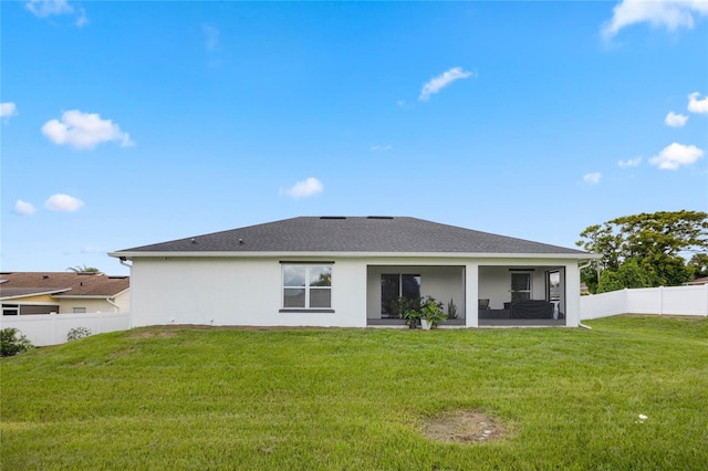 rear view of house featuring a lawn