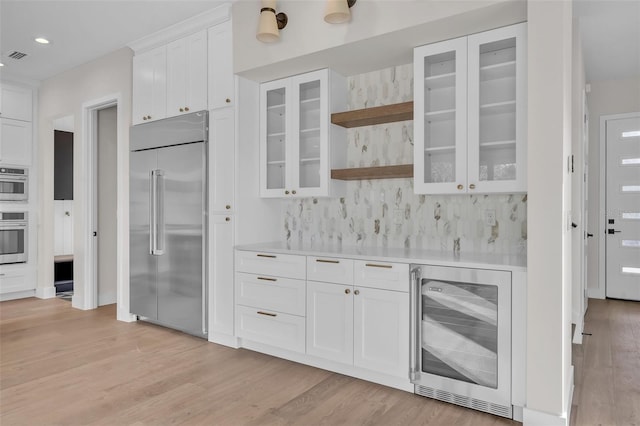 kitchen with white cabinetry, wine cooler, backsplash, stainless steel built in refrigerator, and light hardwood / wood-style flooring