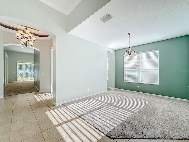 unfurnished room with light carpet, a textured ceiling, and a notable chandelier