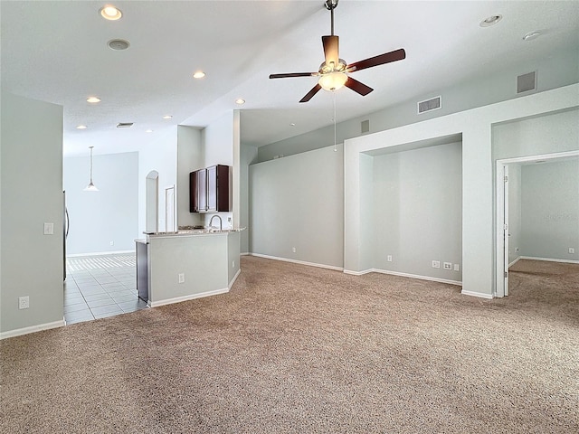 unfurnished living room featuring light colored carpet, sink, and ceiling fan