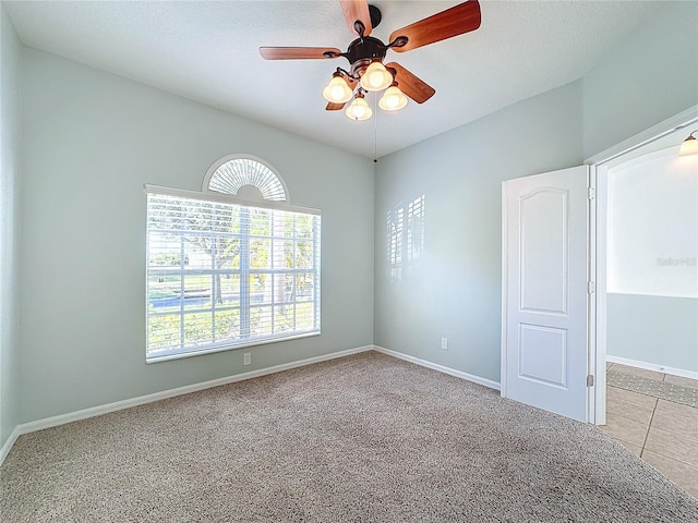 empty room featuring light colored carpet, a wealth of natural light, and ceiling fan