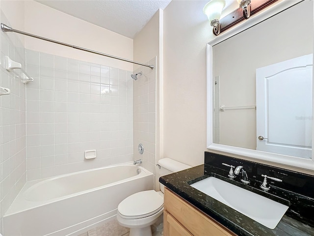 full bathroom with tiled shower / bath combo, vanity, toilet, and a textured ceiling