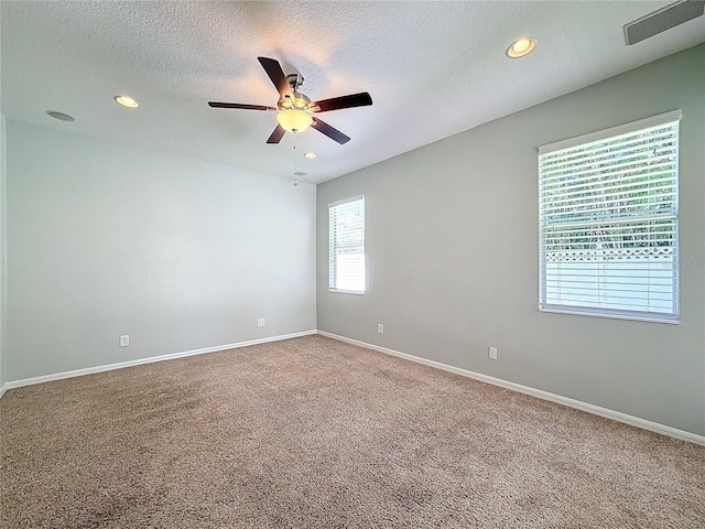 carpeted spare room featuring a textured ceiling and ceiling fan