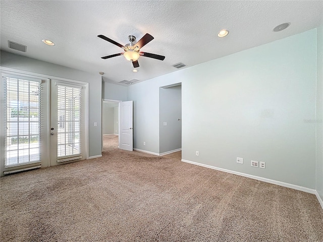 carpeted empty room with ceiling fan and a textured ceiling