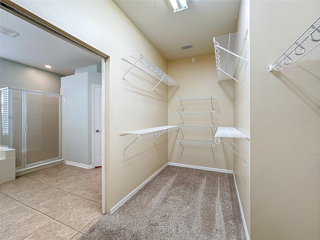 walk in closet featuring light carpet