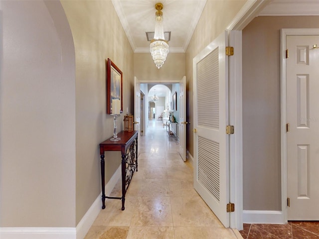 hall with an inviting chandelier and crown molding