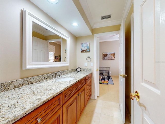 bathroom with tile patterned flooring, ornamental molding, and vanity