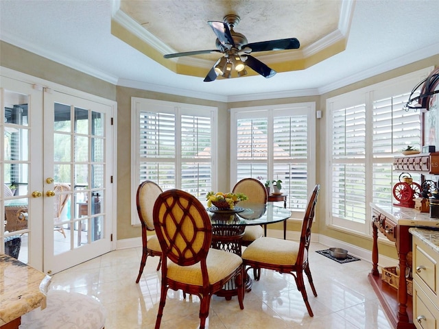 dining space with light tile patterned floors, french doors, and a raised ceiling