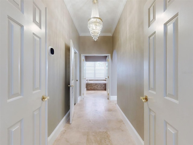 hall featuring crown molding and a chandelier