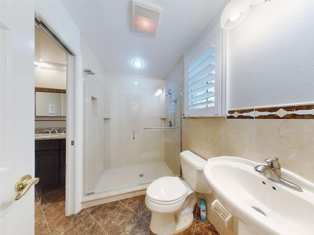 bathroom with tile walls, an enclosed shower, sink, and toilet