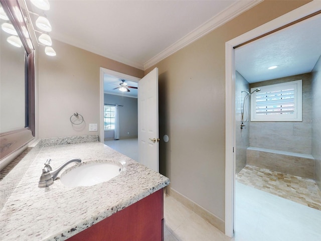 bathroom with ornamental molding, vanity, and a tile shower