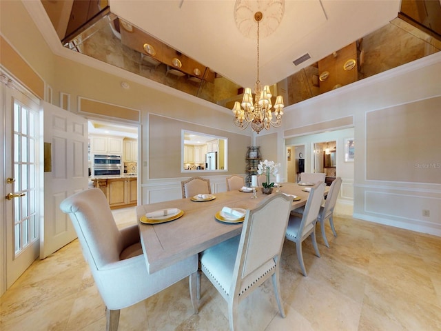 dining space featuring a notable chandelier, french doors, and a high ceiling