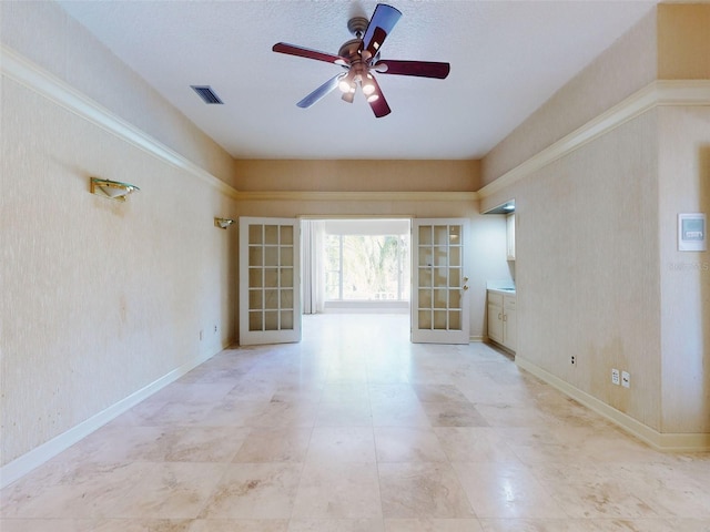 unfurnished room with french doors and ceiling fan