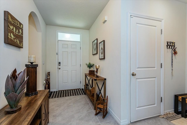 foyer with light tile patterned floors and a textured ceiling